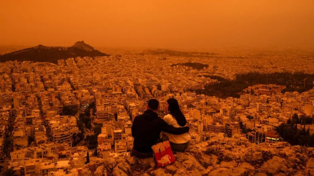 An orange veil descended over the Greek capital on Tuesday, cloaking the Acropolis and parliament in dust