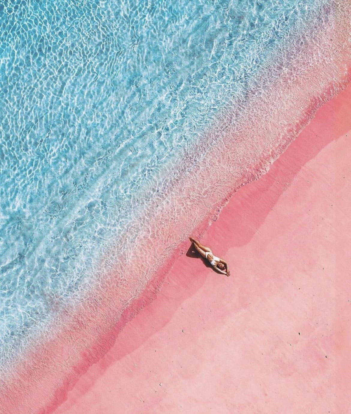 Woman lying on the pink beach on Komodo Island